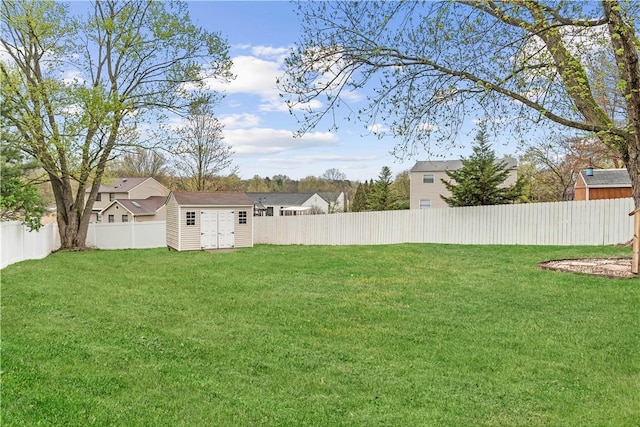 view of yard with a fenced backyard, an outbuilding, and a shed