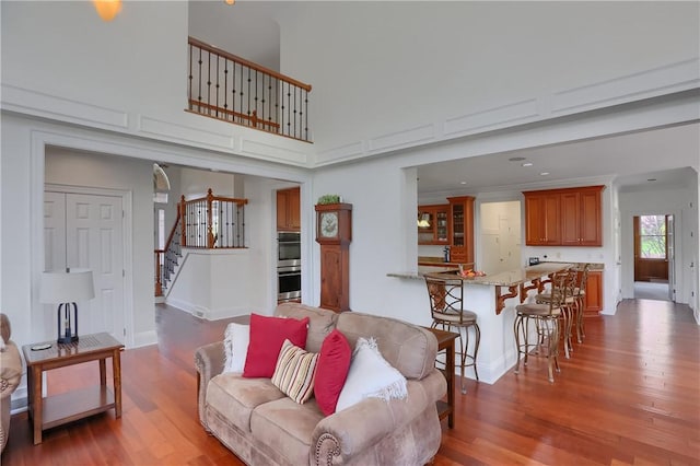 living area featuring baseboards, wood finished floors, and stairway