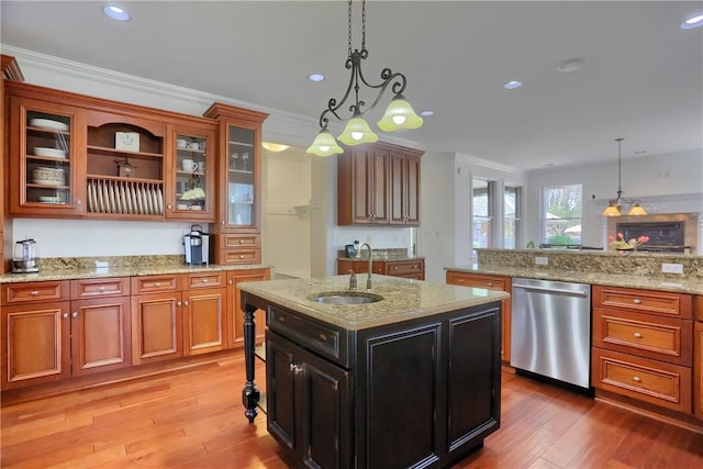 kitchen featuring stainless steel dishwasher, ornamental molding, a sink, light wood finished floors, and decorative light fixtures