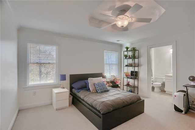 carpeted bedroom with baseboards, ensuite bathroom, and ceiling fan