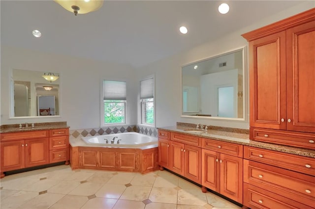 full bathroom featuring a bath, visible vents, two vanities, a sink, and tile patterned floors