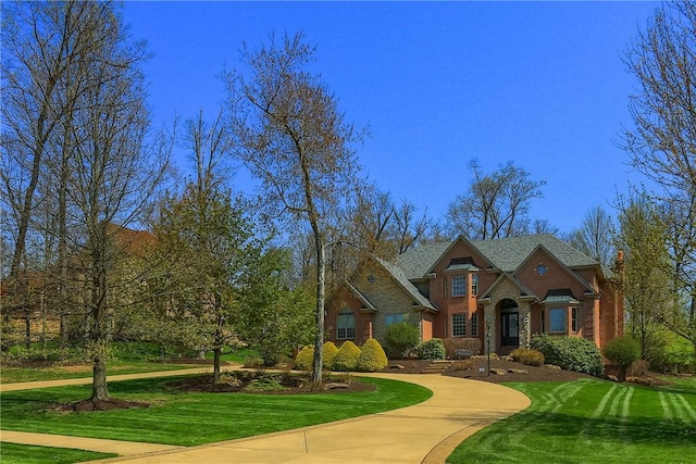 view of front of house featuring brick siding and a front yard
