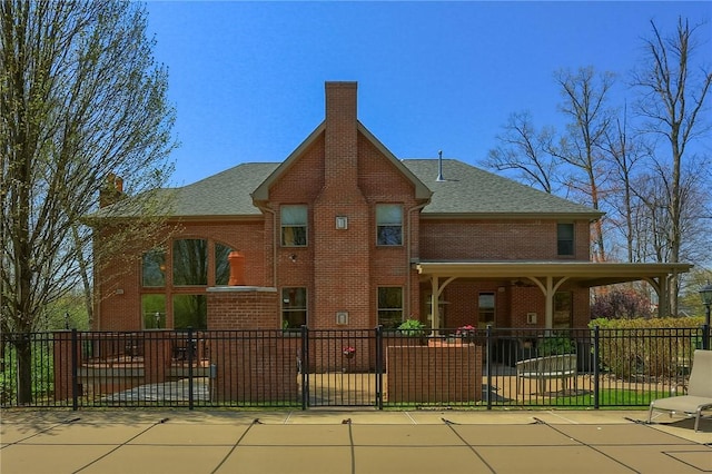 rear view of house with brick siding, fence, and a chimney