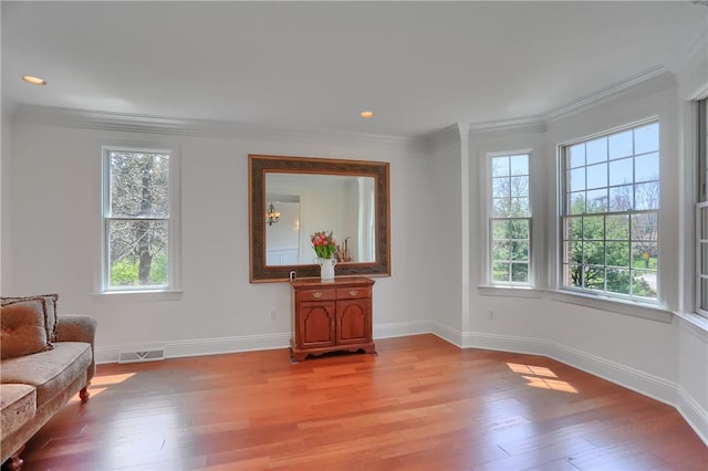 sitting room with crown molding, baseboards, plenty of natural light, and visible vents