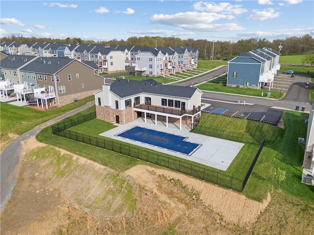 view of swimming pool featuring a lawn, a fenced backyard, and a residential view
