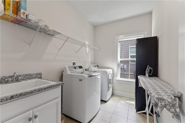 laundry room featuring laundry area, a sink, washer and dryer, and a healthy amount of sunlight
