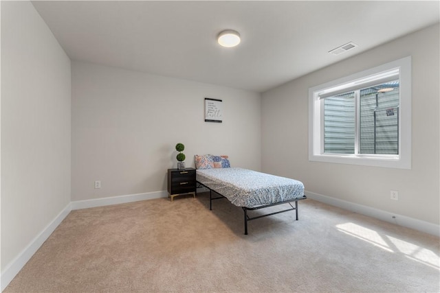 bedroom with visible vents, baseboards, and light colored carpet