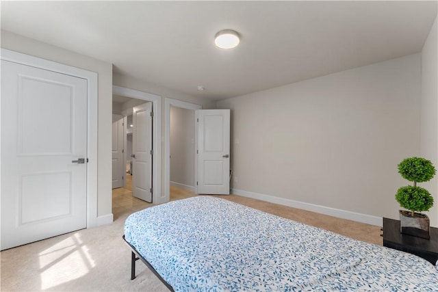 bedroom featuring baseboards and light carpet
