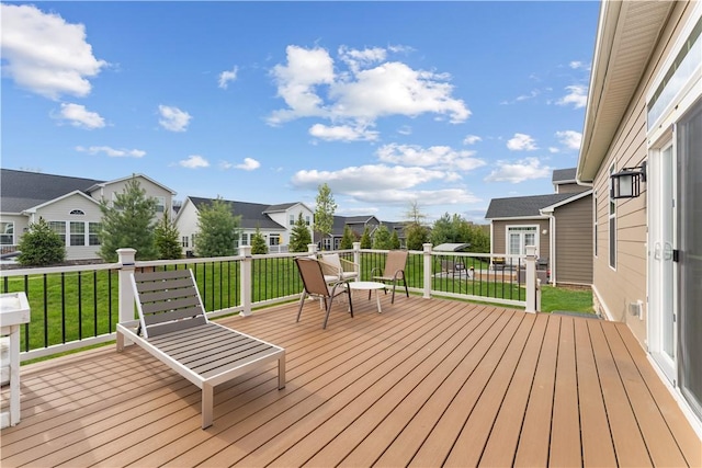 deck with a residential view and a lawn