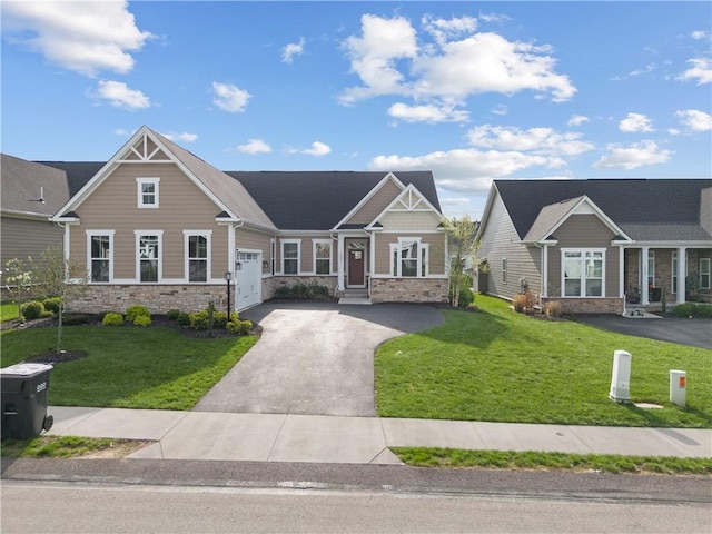 craftsman house featuring a garage, a front lawn, aphalt driveway, and stone siding