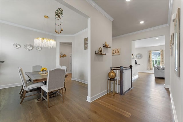 dining room featuring crown molding, baseboards, wood finished floors, and a chandelier