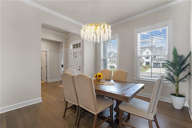 dining room featuring baseboards, a chandelier, ornamental molding, and wood finished floors