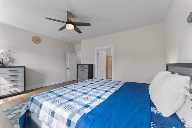 bedroom featuring baseboards, ceiling fan, wood finished floors, and visible vents