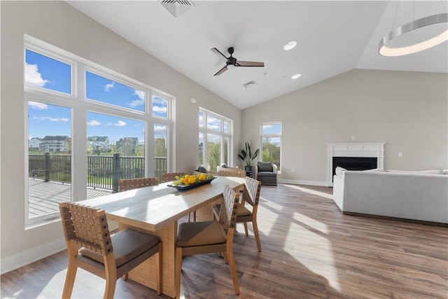 dining room with a healthy amount of sunlight, ceiling fan, wood finished floors, and visible vents