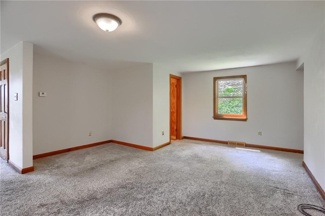 carpeted spare room featuring baseboards and visible vents
