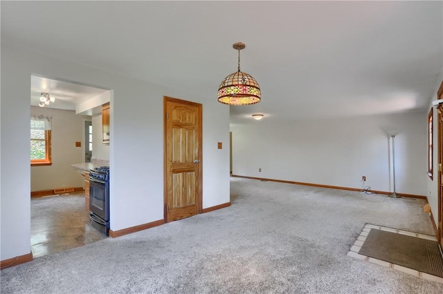 spare room featuring baseboards, light carpet, and a wood stove