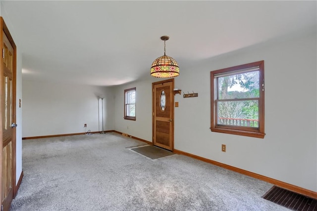 carpeted entrance foyer with visible vents and baseboards