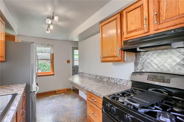 kitchen featuring backsplash, visible vents, appliances with stainless steel finishes, baseboards, and under cabinet range hood