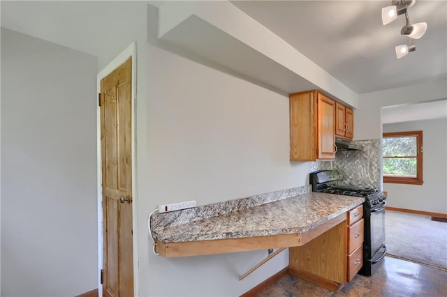 kitchen with brown cabinets, black gas range oven, light countertops, baseboards, and under cabinet range hood