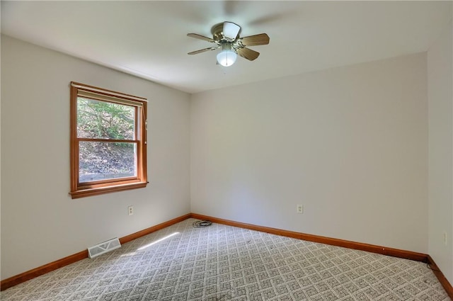spare room featuring visible vents, carpet flooring, baseboards, and ceiling fan