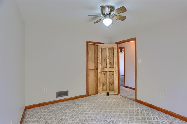 spare room featuring baseboards, light carpet, a ceiling fan, and visible vents