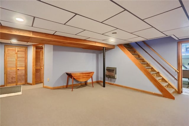 finished below grade area featuring baseboards, carpet flooring, heating unit, and stairs