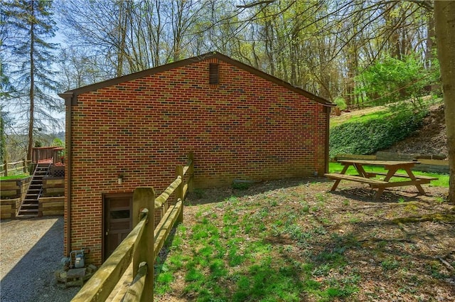 view of side of home with stairway and brick siding