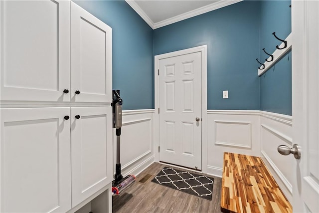 mudroom with crown molding, a decorative wall, wainscoting, and wood finished floors