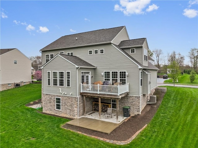 back of house featuring a yard, central AC unit, a shingled roof, and a patio area