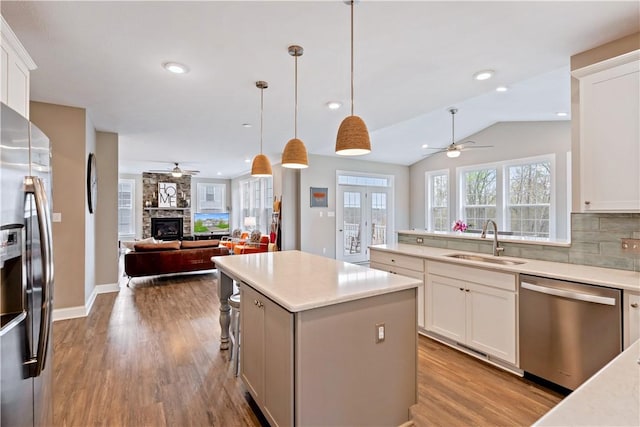 kitchen featuring a sink, appliances with stainless steel finishes, a ceiling fan, and open floor plan