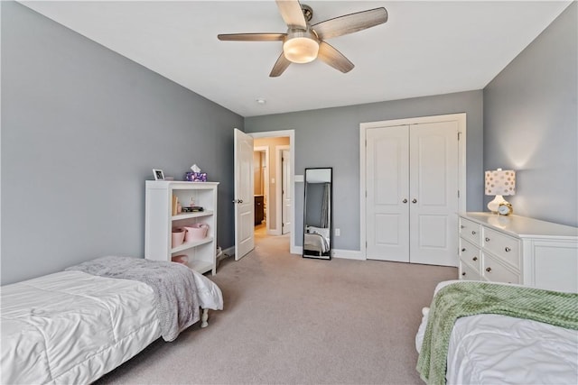 bedroom featuring baseboards, ceiling fan, light carpet, and a closet