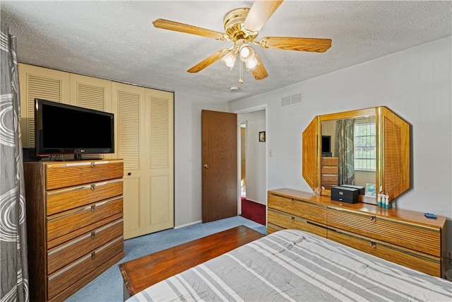 bedroom featuring a closet, dark colored carpet, a textured ceiling, and visible vents