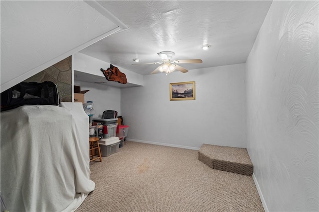 interior space with carpet floors, baseboards, and ceiling fan
