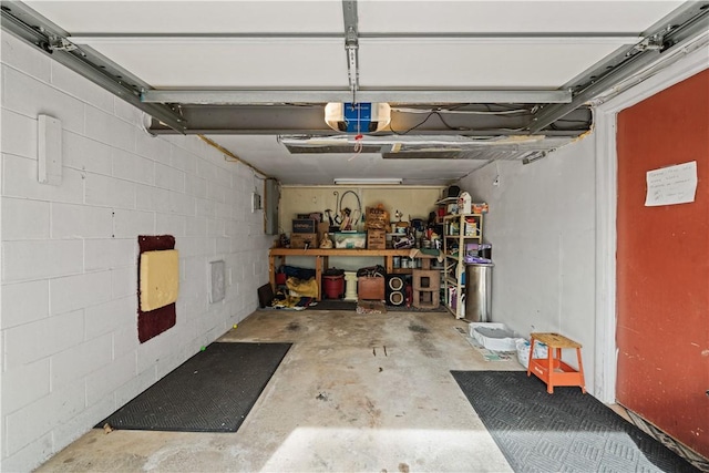 garage featuring concrete block wall and a garage door opener