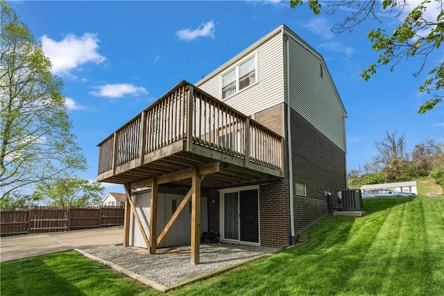 back of property featuring a lawn, a wooden deck, fence, and cooling unit