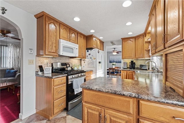 kitchen with a sink, white appliances, a ceiling fan, recessed lighting, and tasteful backsplash