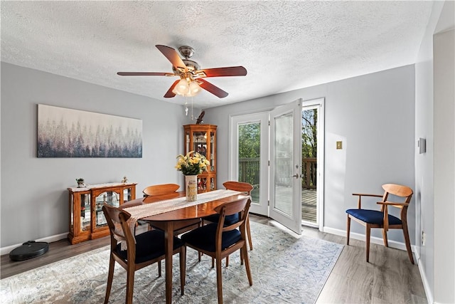 dining room with a ceiling fan, baseboards, and light wood-style floors