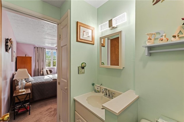 bathroom featuring vanity, ensuite bathroom, and a textured ceiling
