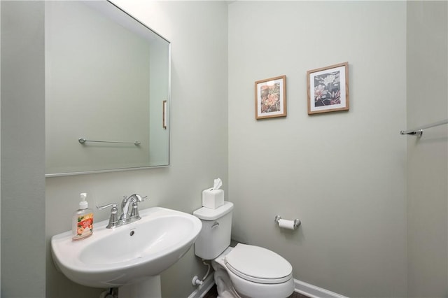 half bath featuring toilet and a sink
