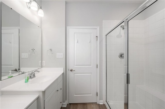 full bath featuring vanity, a shower stall, and wood finished floors