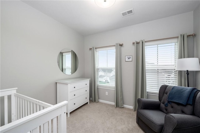 bedroom featuring visible vents, baseboards, a nursery area, and light carpet