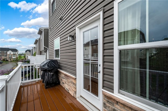 wooden terrace with a residential view and grilling area