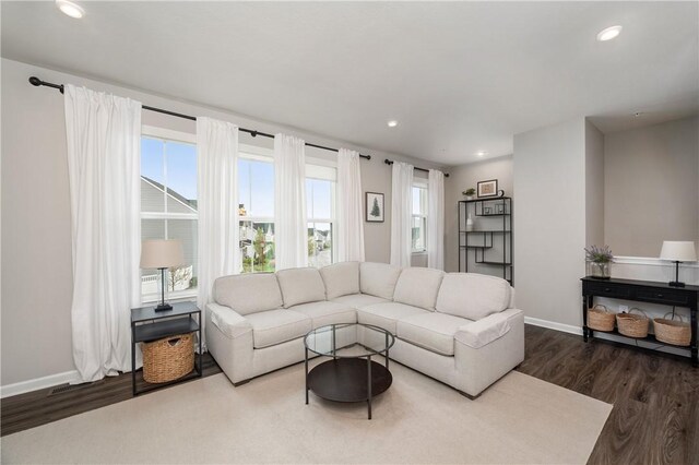 living room with recessed lighting, baseboards, and dark wood finished floors