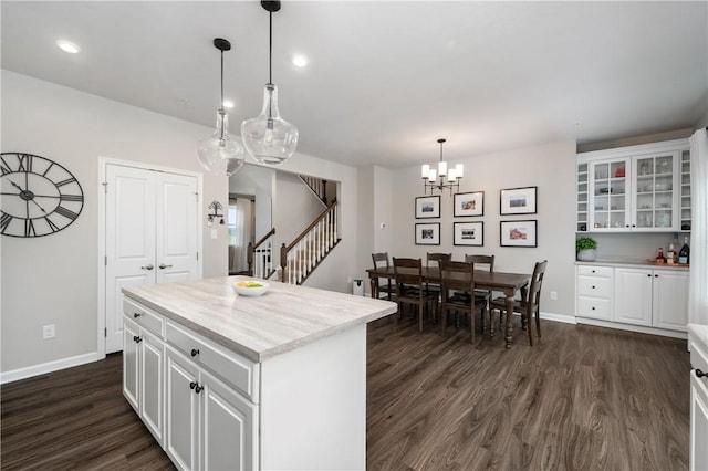 kitchen featuring light countertops, white cabinets, baseboards, and dark wood-type flooring