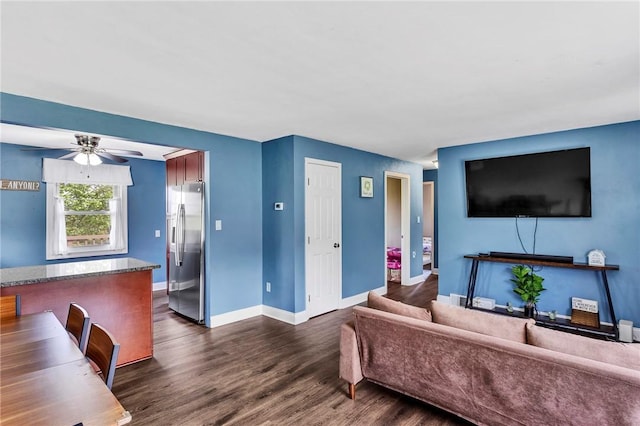 living room featuring ceiling fan, dark wood finished floors, and baseboards