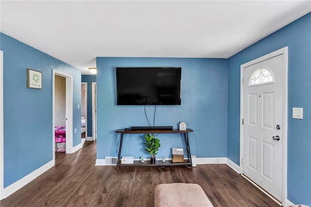 living area with baseboards and wood finished floors