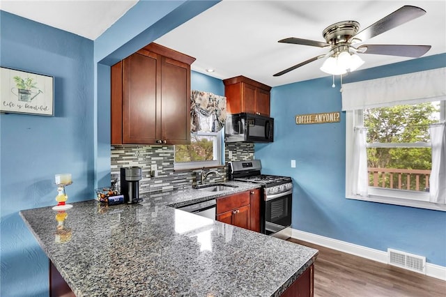 kitchen featuring appliances with stainless steel finishes, a sink, plenty of natural light, backsplash, and visible vents