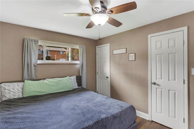 bedroom with dark wood-type flooring, baseboards, and ceiling fan