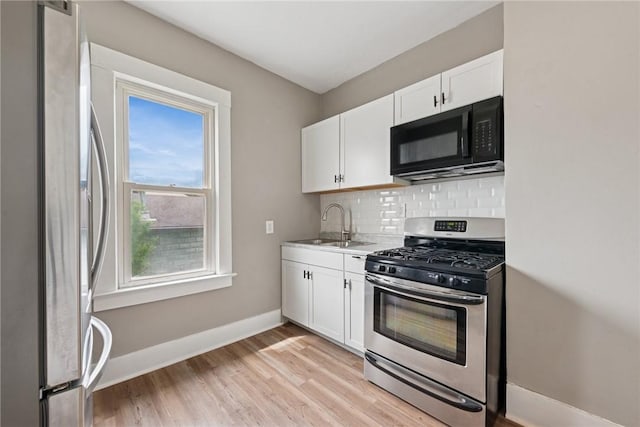 410 Butz St, New Castle/3Rd, PA 16101 - kitchen with light wood-style floors, appliances with stainless steel finishes, backsplash, and white cabinetry