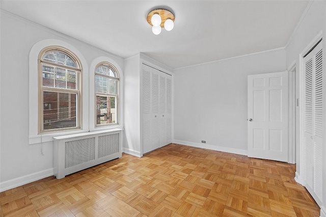 unfurnished bedroom with baseboards, ornamental molding, and radiator heating unit